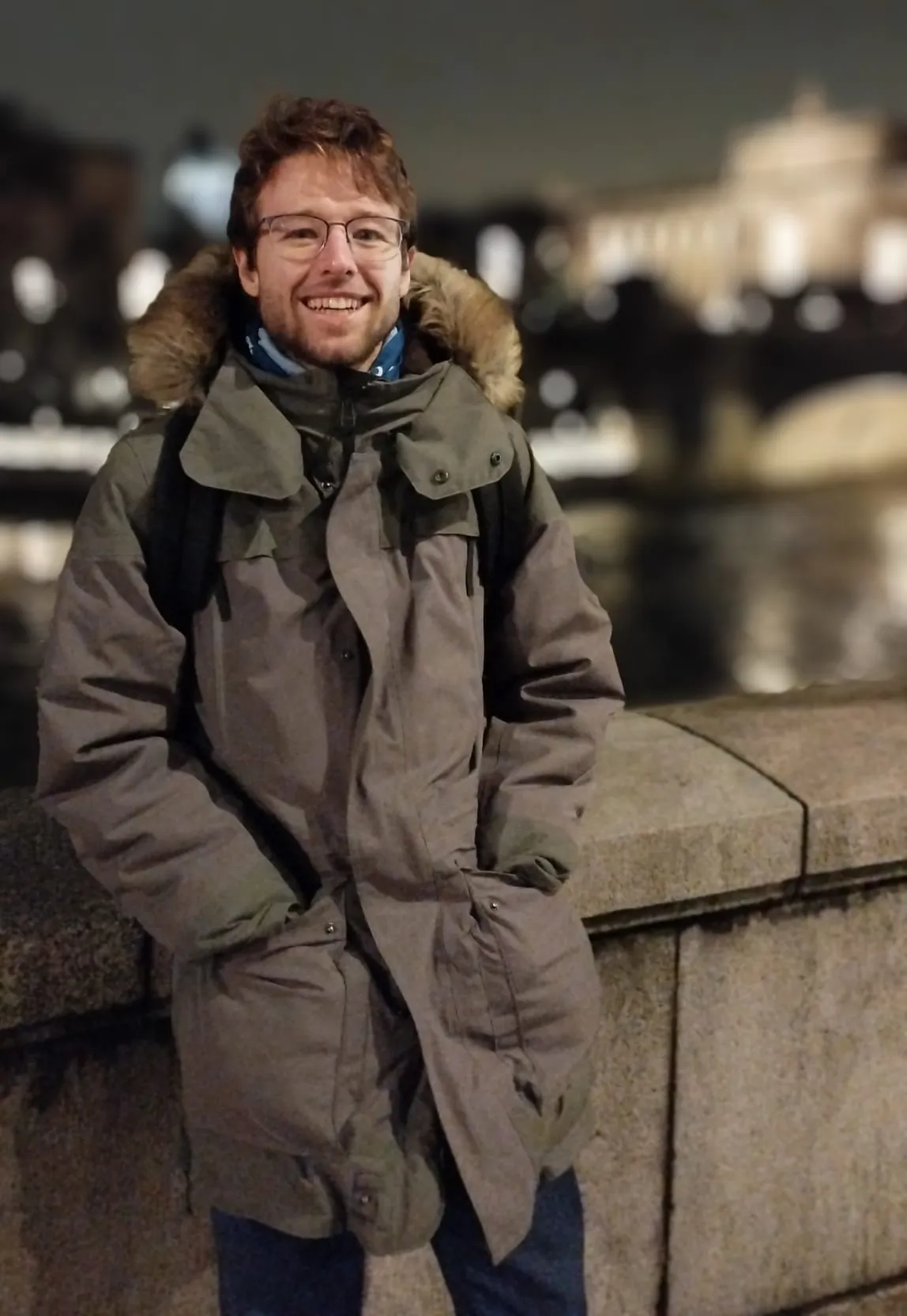 Axel Goris smiling in a winter coat with the swedish parliament in the background